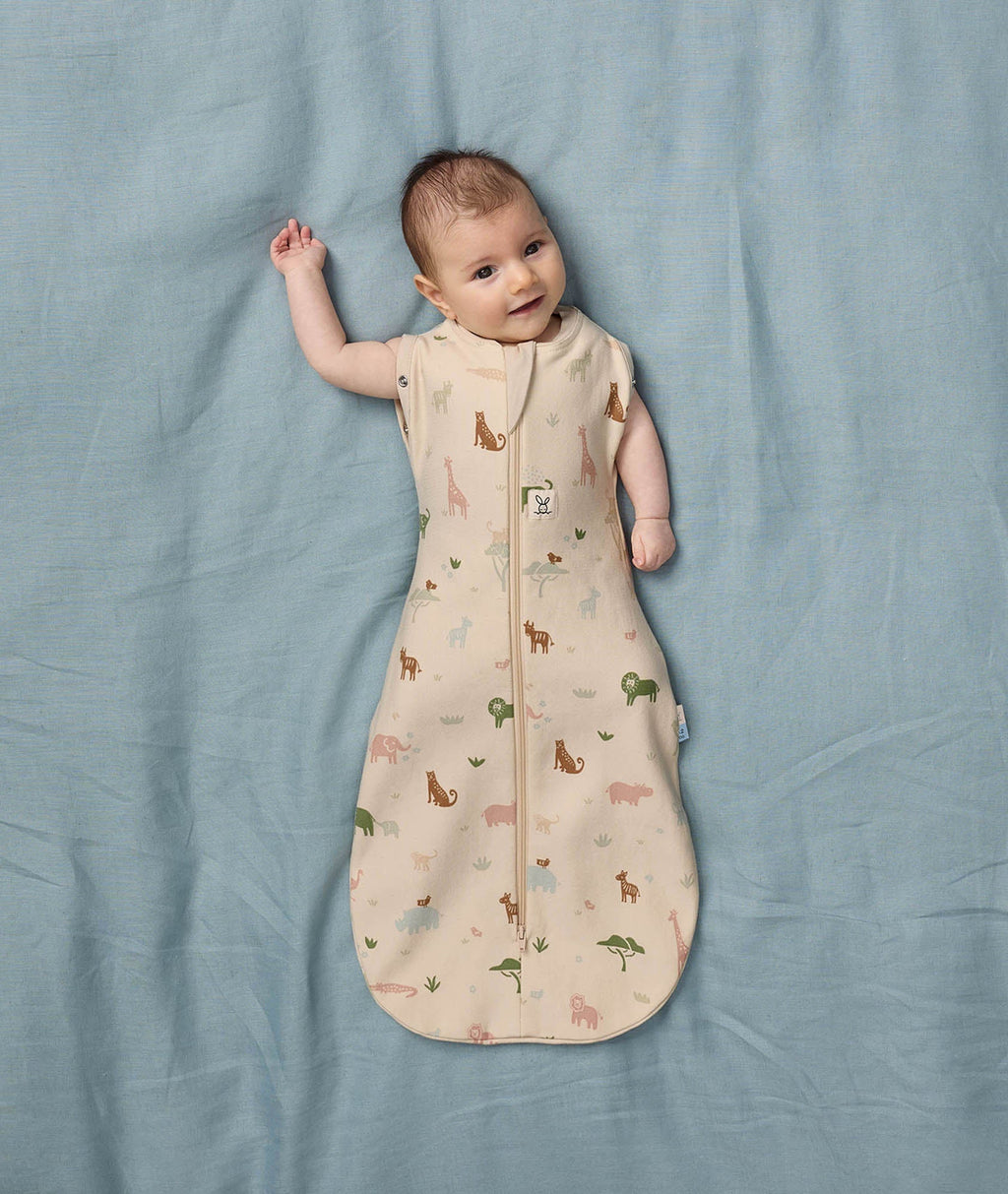 Ergopouch Cocoon inbakerslaapzak Savannah gedragen door baby met de armen uit de zak