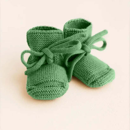 Hvid Booties babyslofjes van merinowol in grasgroen, vooraanzicht
