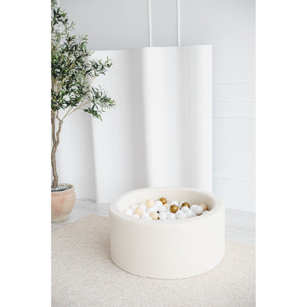 Moje ballenbad bouclé cream in een lichte kamer met plant