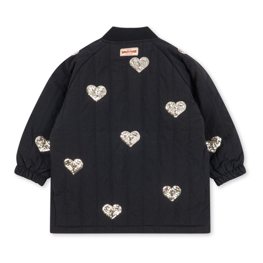 Konges Sløjd Winterjas Juno Sequin Long Jacket Black, lange zwarte winterjas met pailletten op witte achtergrond