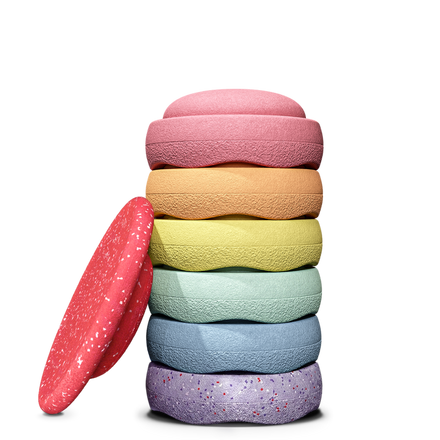 Stapelstein Winter Special Rainbow Set Pastel, zes pastelstenen gestapeld naast het rode board