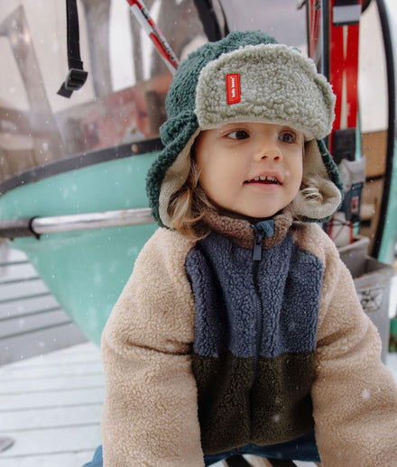 Hello Hossy muts met oorbescherming Cozy Neo, kind met muts bij de skilift